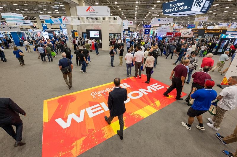 people walk onto the show floor from the GlassBuild 2024 entrance