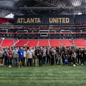 winners stand on the Mercedes-Benz stadium field in front of Atlanta United sign