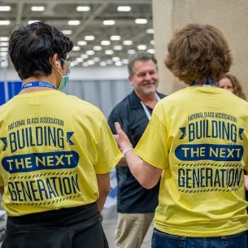 students interact with people on the show floor at GlassBuild