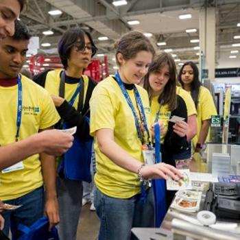 students visit an exhibitor booth at GlassBuild